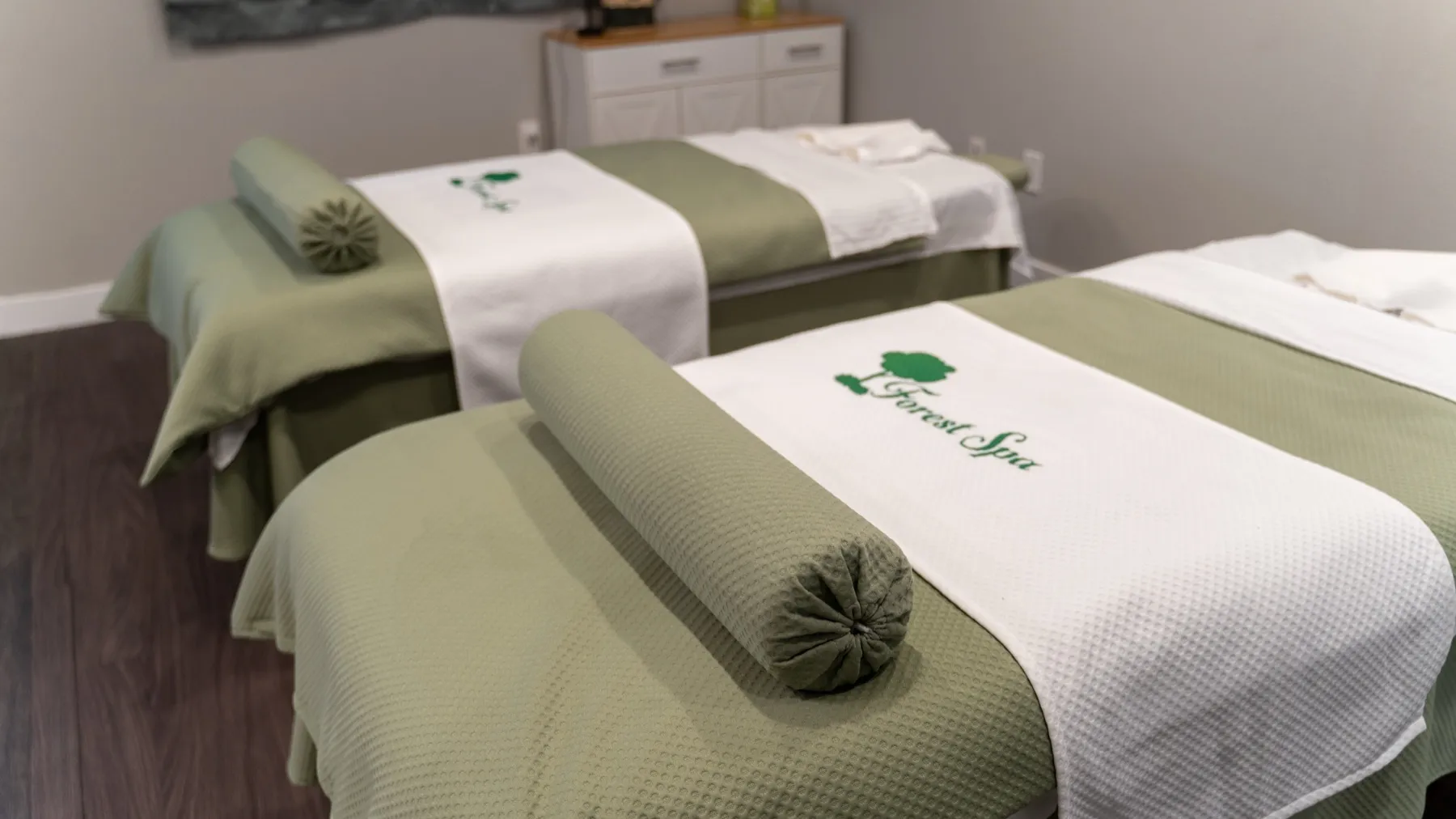 Forest Spa couples suite with two massage tables dressed in sage-green linens